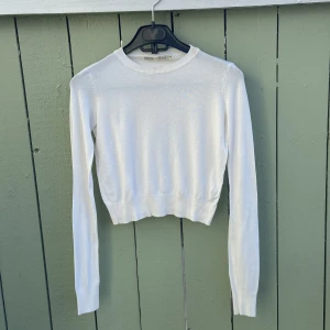 Vit  stickad tröja Bershka,xs - Säljer en vit (croppad) stickad tröja från Bershka. Tröjan har rund halsringning, långa ärmar och ribbade muddar. Enkel och stilren modell som passar perfekt till jeans eller kjol. Superskön och lätt att matcha med allt! mycket bra skick som ny hämtas i norsborg botkyrka.säljer över 1000 plagg allt är mycket bra skick skicka pm tack.