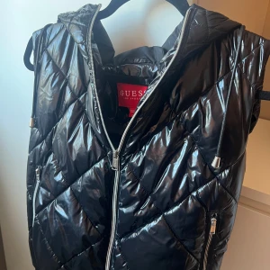 Svart quiltad dunväst från Guess - Guess väst i storlek S, mycket bra skick. 