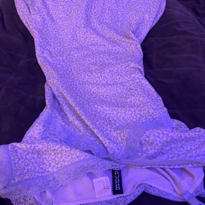 Blommig kortklänning från Divided h&m  - Supersöt kortklänning från Divided med blommigt mönster i ljusa toner och spetsdetaljer längs kanterna. Klänningen har en feminin passform och är perfekt för dig som gillar romantisk stil. Materialet är mjukt och bekvämt bomull. Typ en sov klänning 🩵🩵