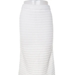 Vit stickad långkjol med slits - Snygg vit stickad långkjol med horisontella ränder i strukturen. Kjolen har en liten slits bak för extra rörelsefrihet och en bekväm midjeresår. Perfekt för dig som gillar en clean och stilren look.