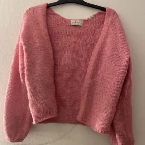 Rosa stickad kofta från ADPT - Mysig rosa stickad kofta från ADPT i storlek XS.Perfekt för lager-på-lager och passar till både jeans och kjol.