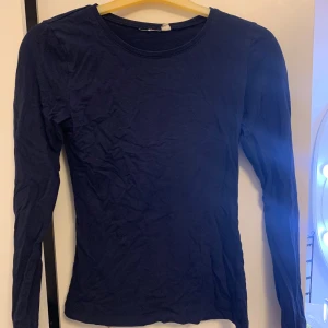 Mörkblå långärmad tröja XS - En basic mörkblå långärmad tröja i slim fit med rund halsringning. Perfekt att ha som lager eller till jeans. Tillverkad i mjuk bomull som känns skön mot huden.