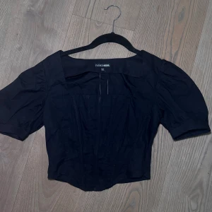 Svart korsettopp - Jättesöt svart topp med puffiga ärmar från Fashion Nova ✨ Dragkedja i sidan för enkel på- och avtagning och sitter superfint på kroppen. Tyvärr för liten i bysten för mig, därför säljer jag den. Aldrig använd och i perfekt skick – prislappen sitter kvar 🤍 - Passar XS Skriv privat för fler bilder eller frågor 🫶🏽 