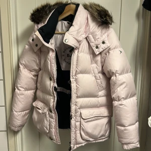 Ljusrosa pufferjacka från Boomerang - Ljusrosa pufferjacka från Boomerang med avtagbar huva och fuskpäls, storlek finns inte på jackan men min dotter har haft den när hon hade storlek 146