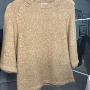 Beige stickad tröja med trekvartsärm - Mysig beige stickad tröja med trekvartsärmar och rund halsringning. Tröjan är från peppercorn!storlek xs/s 