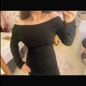 Svart offshoulder långklänning - Säljer en svart långklänning med offshoulder-modell och lång ärm. Klänningen är tight och har en snygg, enkel design som framhäver figuren. Perfekt för dig som gillar stilrena plagg med en twist. Materialet känns mjukt och stretchigt.