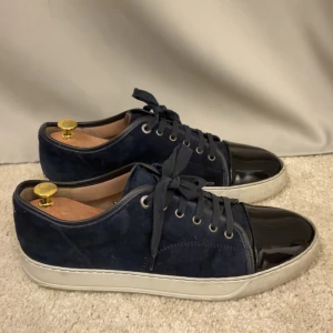Lanvin Skor - Snygga Lanvin skor i modellen Cap Toe. Nya modellen. Färgen är mörkblå/navy. Size Uk 8 vilket motsvarar 42/43. Nypris ligger på 5499. Box och allt og fås med & skoblock. Skriv vid funderingar!  Obs: bilderna är suddiga av någon anledning.