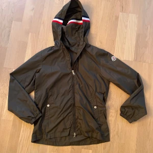 Moncler Windbreaker Size S - Mörkgrön windbreaker från Moncler i mycket fint skick. Den är i storlek 1 i monclers storlek, vilket motsvarar storlek S. Den är i utmärkt skick, inga tecken på användning. Den har en NFC när man scannar Moncler märket, samt en qr kod inne i jackan. Skriv för fler bilder (kan max ta 5 på Plick). Hör av dig om du undrar något!