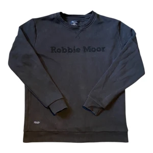 Robbie Moor Sweater - Svart Sweater från Robbie Moor - Fint skick 7/10 - Snygg logga framtil och stilren tomhet på baksidan som får folk att se en som mer framåtriktad med ett tydligt mål - Made in Sweden🇸🇪 - Liten detalj i nedre högra hörnet (se bild 1 och 4) -  80% Varmt bomull 🌤️ - Skönt material som håller under alla väder - Passar till en overshirt, pufferjacka eller ensamt med en smådetaljerad vit t-shirt -  Pris kan alltid diskuteras‼️ och vi tar emot frågor ärligt med öppna armar -  // By Olsén ClosetSvart Sweat