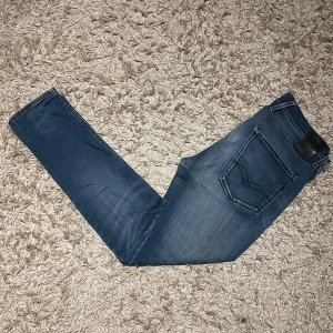 Replay anbass hyperflex med slitningar  - Replay anbass hyperflex jeans i slim passform. Bra skick, lite slitna speciellt i grenen, se bild. Storlek W32. Skön wash på dessa med snygga slitningar, postas samma dag som köp eller dagen därpå🙌💯