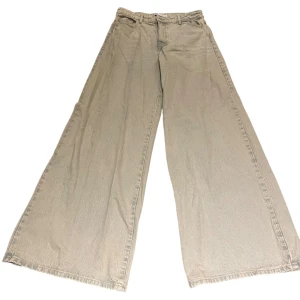Grå/rosa vida jeans från Zara - Säljer ett par ljusgråa/rosa palazzo jeans från Zara i storlek 40. Modellen har supervida ben och ger en baggy look. Materialet är jeans. Är svårt att se på bilder men de har en rosa underton som syns i verkligheten. Super unika och coola! Aldrig använda köpta på sellpy.