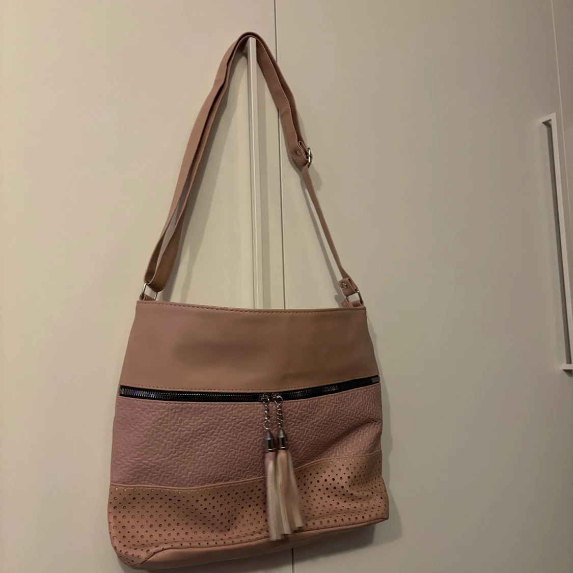 Rosa axelväska med tofsdetalj