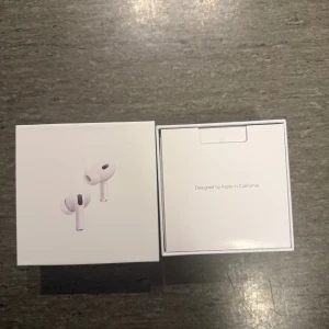 AirPods Pro - Säljer ett par Apple AirPods Pro i originalförpackning. Komplett med laddningsetui, extra öronproppar och laddkabel. Allt ser ut att vara i nyskick utan synligt slitage. Perfekt för dig som vill ha trådlösa hörlurar med aktiv brusreducering och hög ljudkvalitet.