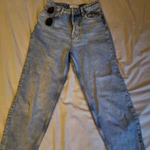 Ljusblå raka jeans från MNG Denim - Säljer ett par ljusblå jeans från MNG Denim med klassisk femficksdesign och raka ben. Jeansen har hög midja och är tillverkade i bomull. Perfekta för dig som gillar en avslappnad och tidlös look.