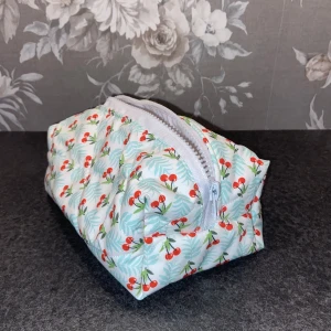 Söt necessär med körsbärsmönster - Egensydd Necessär  med gulligt körsbärsmönster och ljusblå blad. Väskan har en praktisk dragkedja upptill och en boxig form som rymmer mycket. Perfekt för smink eller småprylar i väskan. 