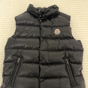 Svart dunväst från Moncler - Hej, säljer nu min dunväst som jag inte använder längre den är i väldigt bra skick och jag har kvitto till den. Den är i storlek 164 cm (motsvarar ungefär xs) och passar perfekt nu till hösten. Kan mötas i Stockholm/ Uppsala området. Pris kan diskuteras.