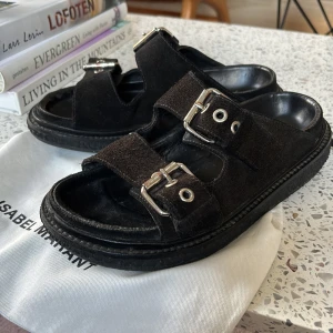 Svarta sandaler Isabel Marant mocka - Svarta sandaler från Isabel Marant i mjuk mocka med två breda remmar och silvriga spännen. Perfekta för sommaren och riktigt snygga till jeans eller shorts. Kommer med dustbag.