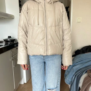 Beige pufferjacka från Zara med huva - Säljer en beige vinterjacka från Zara, knappt använd och i superbra skick. Varm, bekväm och perfekt för vintern. Snygg passform och lätt att matcha till allt. Nypris: 599 kr