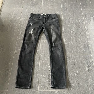 Levi's 510 Skinny svarta jeans - Svarta Levi's 510 Skinny jeans med slitna detaljer och trasiga partier på framsidan. Klassisk femficksmodell med knapp och dragkedja. Jeansen har en smal passform och är tillverkade i jeansmaterial med lite stretch för extra komfort.