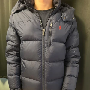 Mörkblå dunjacka från Polo Ralph Lauren - Strl S men passar M bra skick. Tveka inte på att fråga frågor. Kan gå ner i pris vid snabb affär. 
