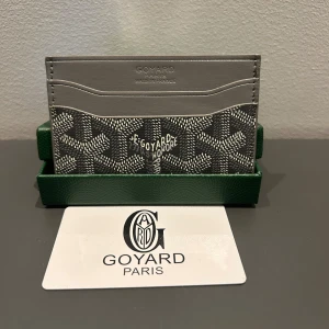 Grå  plånbok med mönster - Slimmad och stilren plånbok från i grått  med ikoniskt grafiskt mönster. Flera kortfack på båda sidor och gul insida. Perfekt för dig som vill ha en lyxig och tunn plånbok med Paris-vibe.