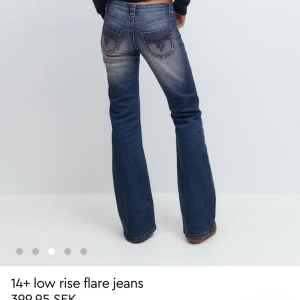 Mörkblå low rise bootcut jeans - Snygga mörkblå jeans med låg midja och bootcut passform. Jeansen har röda detaljer. Storlek L men passar som M också. Aldrig använda. Säljer för 200 och de säljs för över 300 i butik.