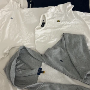 Grå hoodie från Polo Ralph Lauren, två vita t shirts från ralph Lauren och lyle & scott, en marinblå t-Shirt gant  - Snygg grå hoodie från Polo Ralph Lauren med klassisk blå logga på bröstet. Tröjan har huva, dragkedja och mjukt vitt foder på insidan. Även 2 vita t  shirts från Ralph Lauren och lyle & scott, en marinblå gant t Shirt. Perfekt för chill dagar och enkel att matcha med jeans eller joggers.kom privat diskutera pris!