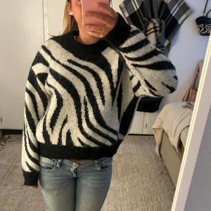 Zebramönstrad stickad tröja - Säljer en supermjuk stickad tröja från Gina Tricot med svartvitt zebramönster. Lite nopprig men annars i fint skick! 🤩