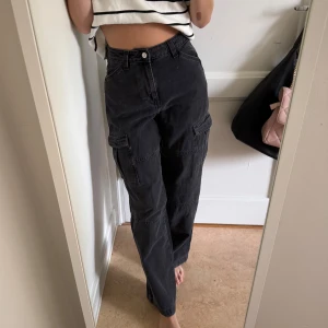 Svarta cargobyxor  - Svarta cargobyxor från H&M med raka ben och flera praktiska fickor på.