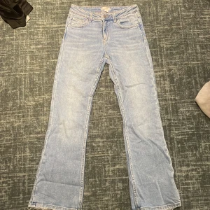 Ljusblå bootcut jeans Gina Tricot - Snygga ljusblå jeans från Gina Tricot i bootcut-modell med råa, fransiga benslut. Klassisk femficksdesign och normal passform. Perfekta för dig som gillar en avslappnad och trendig look. Tillverkade i jeansmaterial.