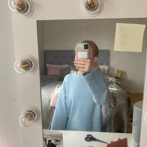 Ljusblå stickad tröja från Gina Tricot - Supermysig ljusblå stickad tröja från Gina Tricot med breda ribbade muddar och avslappnad passform. Perfekt för lager på lager och har en enkel, stilren look med rund hals och långa ärmar. Aldrig använd💕