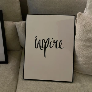 inspire - En stilren poster med ordet 'inspire' i snygg handskriven stil. Perfekt för att ge motivation och energi till ditt rum eller studiehörna. Passar dig som vill ha en modern och inspirerande inredningsdetalj.