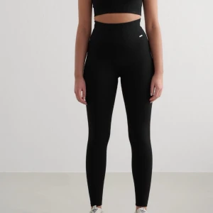 Svarta ribbade leggings med hög midja - Svarta leggings med ribbad struktur och hög midja. Tight passform som sitter snyggt och bekvämt, perfekta till träning eller chill. De är använda fåtal gånger och är i ett mycket bra skick, priset kan diskuteras🫶🏽🩷storlek M 