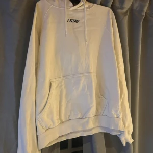 Vit hoodie från I STAY med huva - Vit hoodie från I STAY med broderad text på bröstet. Tröjan har huva med snörning, stor magficka och ribbade muddar vid ärmslut och nederkant. Perfekt för en chill och avslappnad stil.