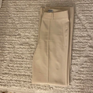 Kostymbyxor från Madlady - Ljusbeiga kostymbyxor från Madlady stl 34 längd 34. Använda vid ett tillfälle.