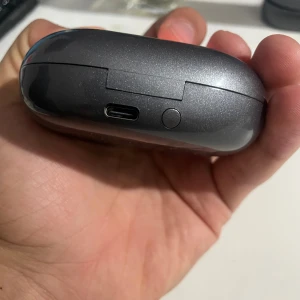 YYK-Q16 Pro Wireless Earphones - Snygga trådlösa hörlurar med laddningsetui och digital display. Modell YYK-Q16 Pro, USB-C laddning, blank finish och kompakt design. Hörlurarna och etuiet ser ut att vara i mycket gott skick utan synligt slitage eller repor. Perfekt för musik och samtal på språng.