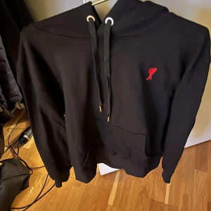 Svart hoodie med unikt hjärt märke - En svart hoodie i nytt skick med rött hjärta på priset kan sänkas vid snabb affär s men passar m!