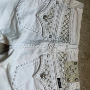 Vita jeans från Miss Me, strl 28 - Snygga vita jeans från Miss Me med dekorativa bakfickor. Midjemått 39/40cm, Innerbenslängd 77cm, ytterbens längd 97/98cm. En knapp är borta (Se sista bild) Annars superbra skick! Kan diskutera priset💓