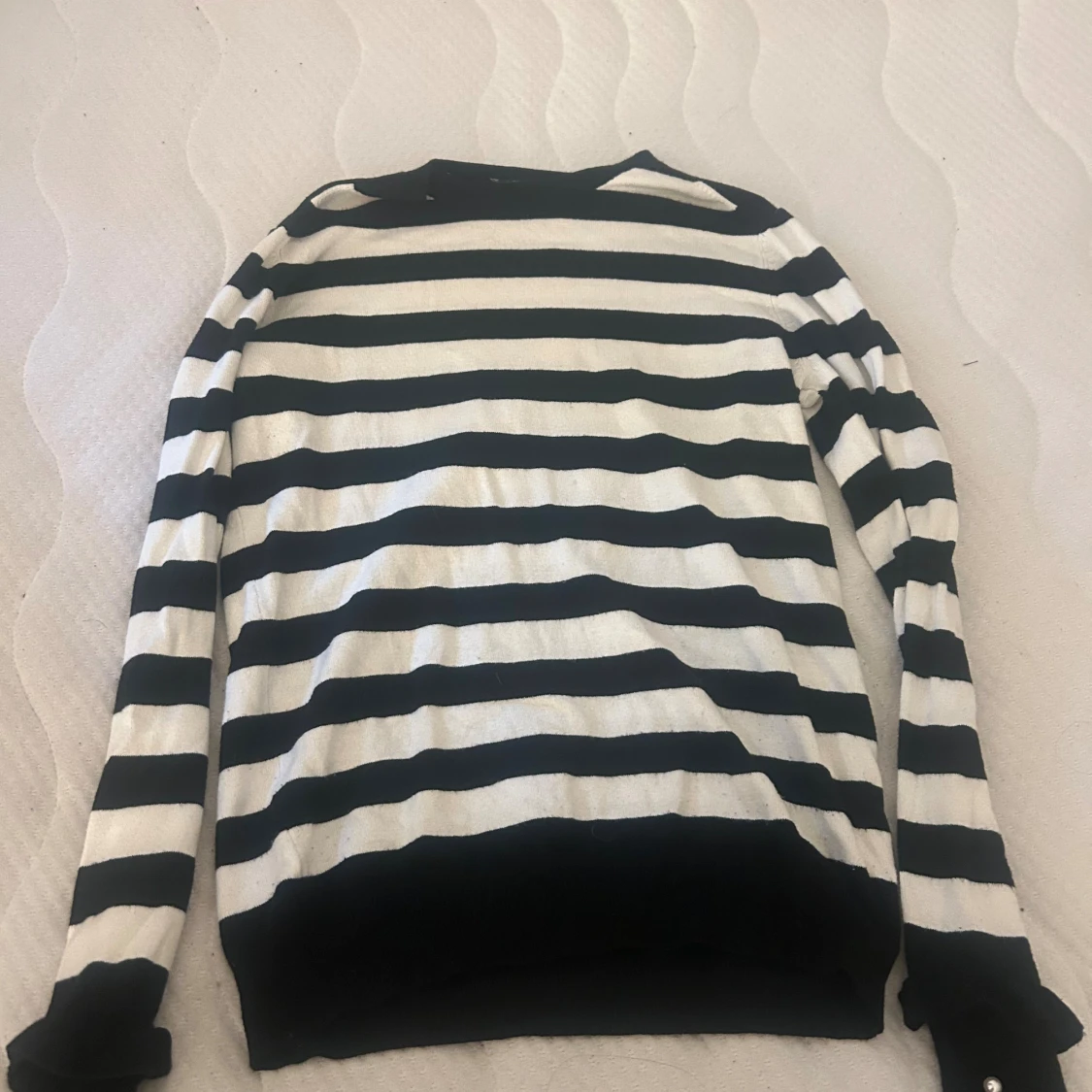 Randig svartvit stickad tröja med pärldetaljer