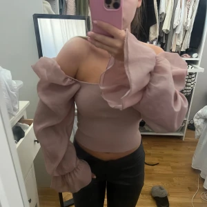 TOPP MED VOLANG - Supersnygg topp i gammeldags rosa. Använd en gång!! Den är lite sliten vid armen efter tvätt därav priset🩷Superfin och söt!!