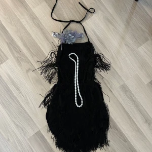 Fransklänning med shorts - Fransklänning med shorts, glittrigt pannband och ett pärlhalsband. Perfekt för halloween eller gatsby temafest. Endast använt en gång!