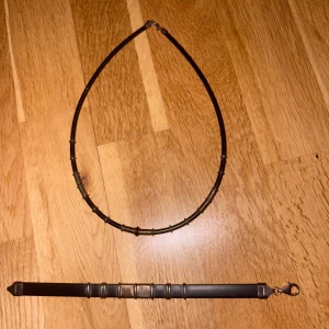 Set med halsband och armband i silver - Säljer ett stilrent set med halsband och armband i äkta 925 silver. Båda har en svart bas med silverfärgade detaljer i ett geometriskt mönster. Perfekt för dig som gillar minimalistisk och edgy stil.