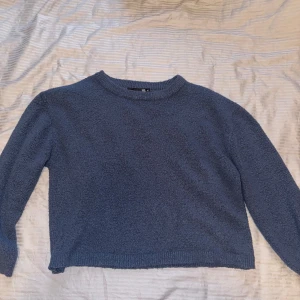 Blå stickad tröja från 157 - Mysig blå stickad tröja från 157 med rund halsringning och ribbade muddar. 