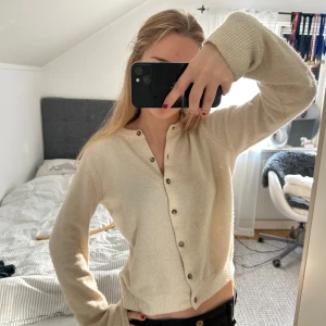 Vit stickad kofta - Gullig krämvit kofta! Den är ganska nopprig därav billigt pris. Märket är okänt då lappen är borttagen. Säljer då den inte kommer till användning. 