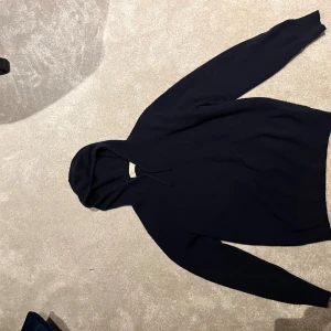 Mörkblå kashmir hoodie från Sayless - En 1 år gammal sayless hoodie i storlek xs. Tröjan visar tecken på användning genom exempelvis lite knotter och ett litet hål i armhålan, passar cirka 160-170 cm.