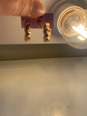 Guldtonade tvinnade hoops örhängen - Säljer ett par snygga örhängen i guldtonad metall med tvinnad design. De är små till medelstora hoops som ger en trendig och elegant look. Perfekta för dig som gillar stilrena accessoarer med det lilla extra.