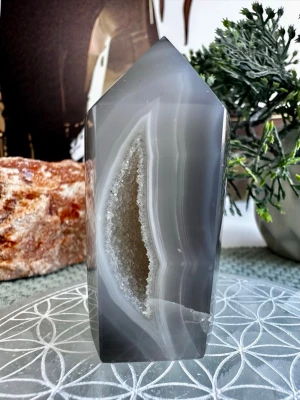 Agat druzy torn - Vackert polerat torn i grå bandad agat med naturlig druzy-ficka som gnistrar så vackert i ljuset.  75 gram 6.5 cm hög.   Agat är en stabiliserande och grundande sten som hjälper vid stress, oro och överstimulans. Mild energiförstärkning – perfekt även för känsliga personer.   Har en video av den på min Instagram: Sannastenar.