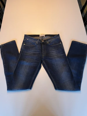 Acne Studios - Snygga blå Acne Studios - MAX PRINCE slim jeans. Jeansen har en mörk tvätt med subtila slitningar. W29 L32.