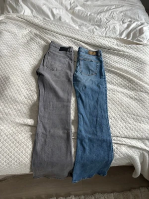 Två par utsvängda jeans i grått & blått - Säljer två par utsvängda jeans, ett i grå denim och ett i klassisk blå denim. De blåa är storlek S och de gråa är storlek M. De gråa har ett litet hål längst ner men inget man ser tydligt. Dem tvättas SÅKLART innan de skickas 🥰 Få båda för 100 eller ett par för 70! 