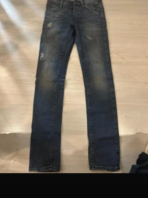 Jack and Jones italia jeans - Snygga blå Levi's 514 jeans med straight fit och klassisk femficksdesign. Jeansen har slitna detaljer och ljusa partier på låren för en cool, använd look. Tillverkade i tåligt denim med normal passform och knappgylf.